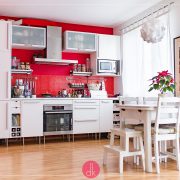 Czerwona ściana w kuchni i białe meble