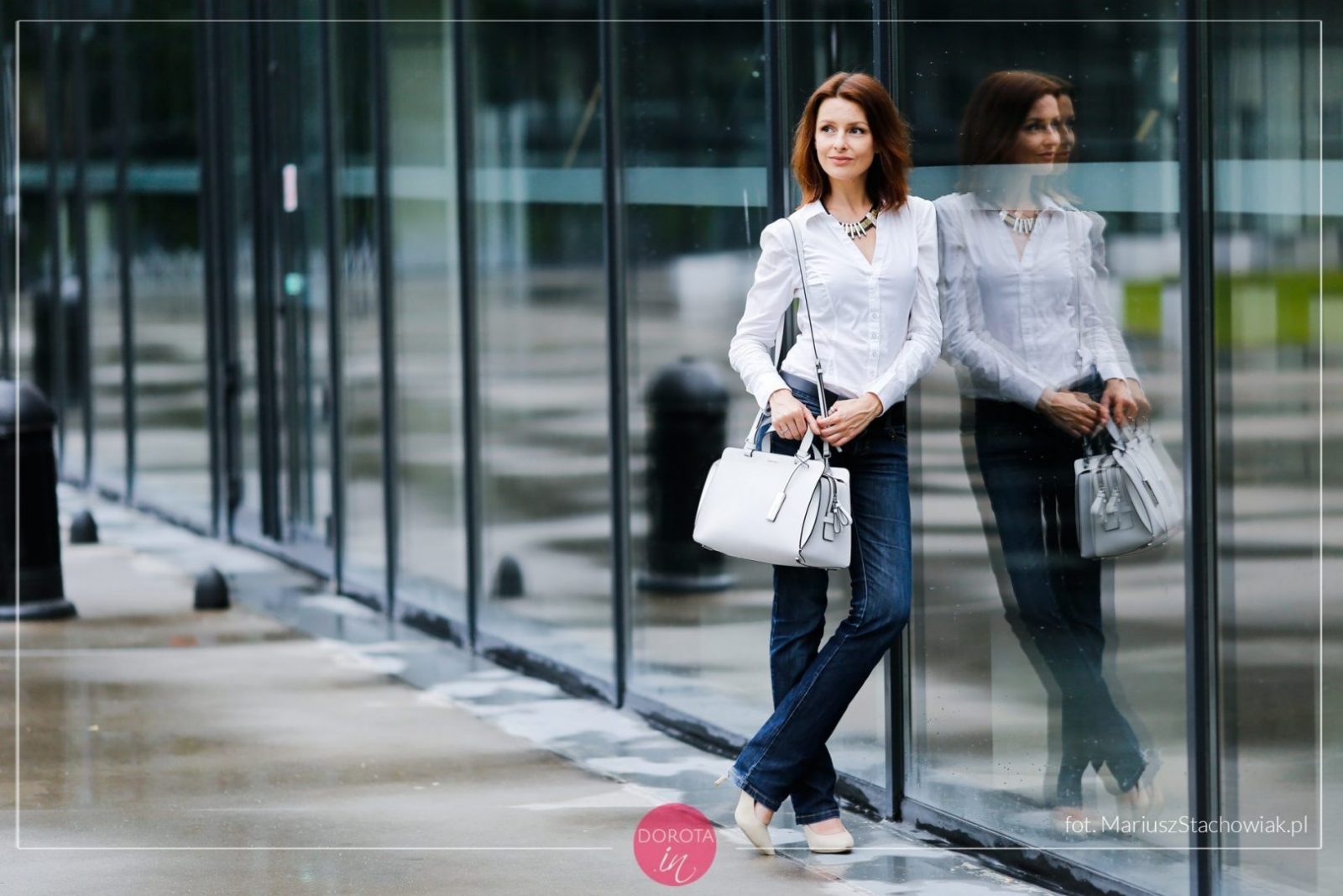 Biała koszula i granatowe dżinsy - stylizacja z białą torebką