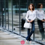 Biała koszula i granatowe dżinsy - stylizacja z białą torebką