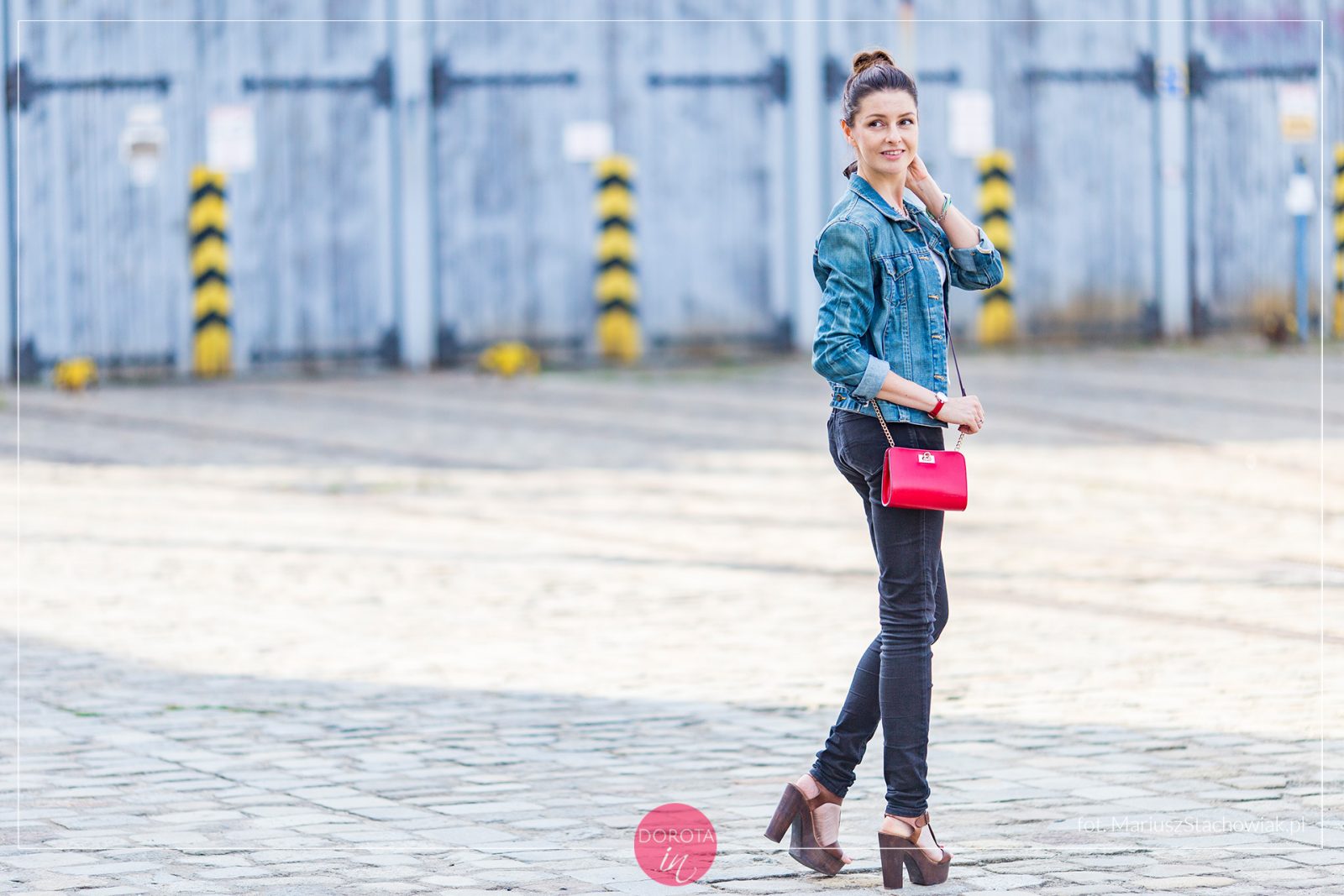 Dzinsowa kurtka, czarne spodnie, wysokie sandały i czerwona torebka
