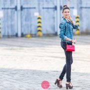 Dzinsowa kurtka, czarne spodnie, wysokie sandały i czerwona torebka