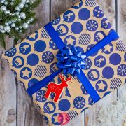 Prezent spakowany w szary papier z granatową wstążką i niebieskim wzorem